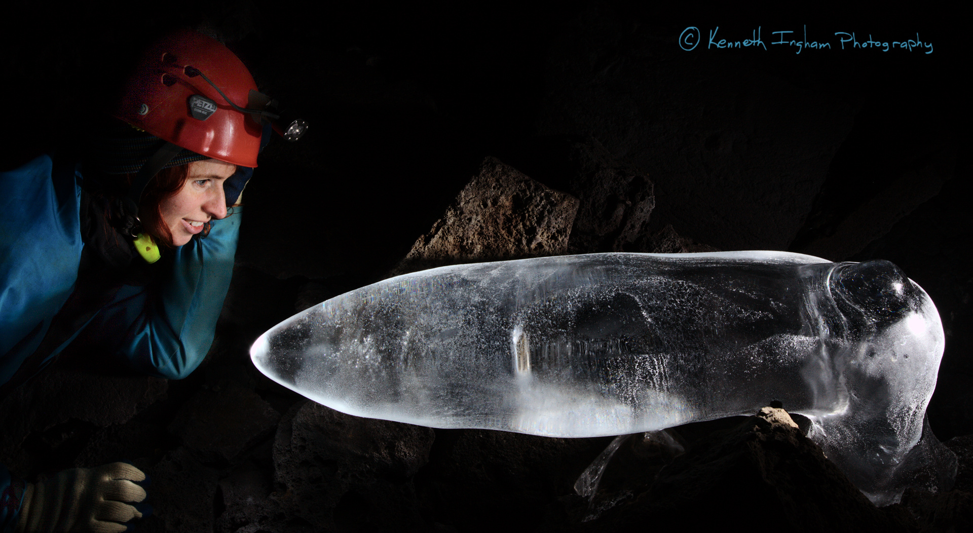 Caver looking at a bent ice stalagmite